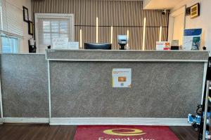 a reception desk with a counter with a red carpet at Econo Lodge Woodstock - Shenandoah Valley I-81 in Woodstock