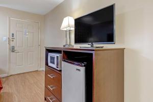 a room with a microwave and a television on a wall at Econo Lodge Woodstock - Shenandoah Valley I-81 in Woodstock