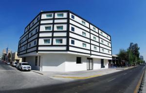 un edificio blanco y negro al lado de una calle en Hotel Portonovo Plaza Centro, en Guadalajara