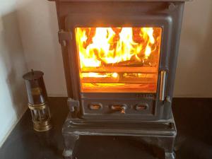 a stove with a fire inside of it at Cloverfield in Bamburgh