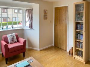 a living room with a chair and a window at Cloverfield in Bamburgh