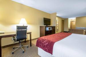 a hotel room with a bed and a desk and a chair at Comfort Suites Wisconsin Dells Area in Portage