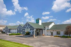 a large building with a clock tower in a parking lot at Quality Inn & Suites Stoughton - Madison South in Stoughton