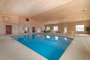 a swimming pool in a room with a wooden ceiling at Quality Inn & Suites Stoughton - Madison South in Stoughton