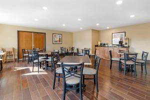 a restaurant with tables and chairs and a kitchen at Quality Inn & Suites Stoughton - Madison South in Stoughton