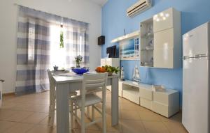 a kitchen with a table with chairs and a refrigerator at 1 Bedroom Beautiful Apartment In Trappeto in Trappeto +9 photos