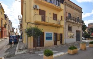 a yellow building on the side of a street at 1 Bedroom Beautiful Apartment In Trappeto in Trappeto