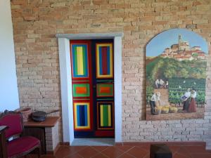 a colorful door in a brick wall with a painting at Da Elvira in Costigliole dʼAsti