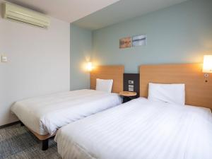 two beds in a hotel room with white sheets at Comfort Hotel Kure in Kure +43 photos