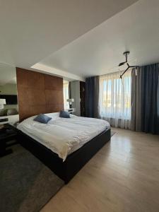 a bedroom with a large bed and a large window at Empire City in Karagandy +27 photos