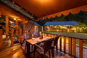 a wooden deck with a table and chairs on it at Dandeli Kali Resort in Dandeli