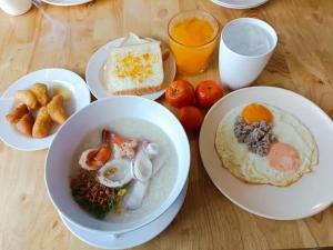 a table with plates of breakfast foods and drinks at Hotelru Koh Larn-โฮเต็ลรุ เกาะล้าน in Ko Lan