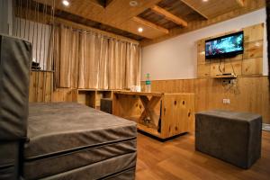a room with a table and a tv on a wall at Mountainshack Riverside Stay & Cafe in Kulu