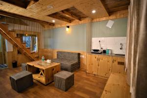 a living room with a table and a kitchen at Mountainshack Riverside Stay & Cafe in Kulu