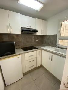 a kitchen with white cabinets and a sink at Le Cocon de Didon in Tunis