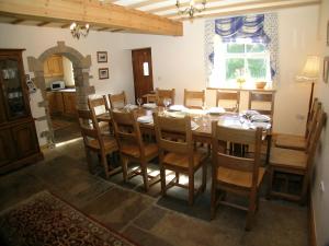 a dining room with a wooden table and chairs at Scarr House Farm in Muker