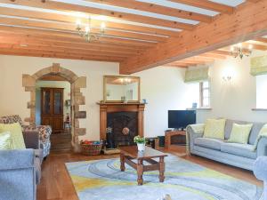 a living room with a couch and a fireplace at Scarr House Farm in Muker
