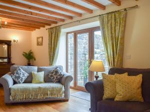 a living room with a couch and a large window at Scarr House Farm in Muker