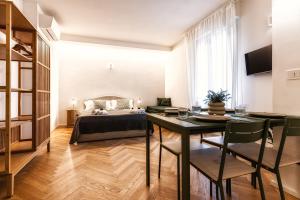 a bedroom with a bed and a table with chairs at Boccaccio Apartment 3 in Ravenna