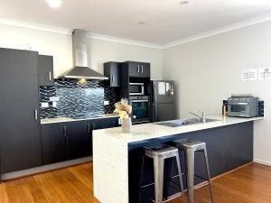 a kitchen with black cabinets and a white counter top at 14A Convenient Ensuite Room in Coopers Plains in Brisbane