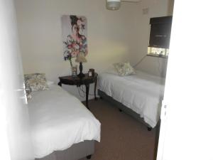 a bedroom with two beds and a tv on the wall at Chickpea Villa in Bergview