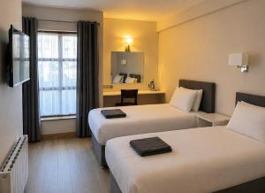 a hotel room with two beds and a window at Blue Water House in Bundoran