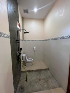 a bathroom with a toilet in a room at Pandan Arum Surfing in Pulau Lutung