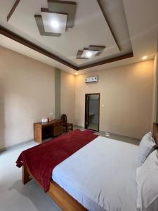 a bedroom with a large bed and a desk at Pandan Arum Surfing in Pulau Lutung +31 photos