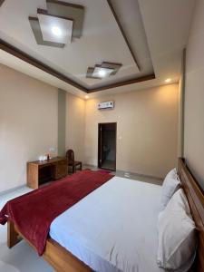 a bedroom with a large bed and a desk at Pandan Arum Surfing in Pulau Lutung