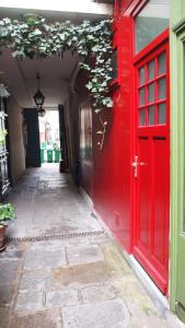 a red door on the side of a building at Petit Paris - Oasis in Marais in Paris