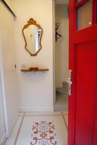 uma casa de banho com uma porta vermelha e um espelho em Petit Paris - Oasis in Marais em Paris