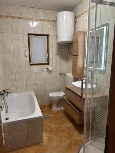 a bathroom with a tub and a toilet and a sink at Alf Rab in Rab +32 photos