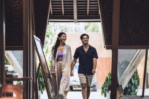 a man and a woman walking down the stairs at Kaamala Resort & Spa Ubud by Ini Vie Hospitality in Ubud