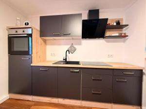 a kitchen with a black refrigerator and a sink at Zwischen Donau & Kurpark in Bad Abbach