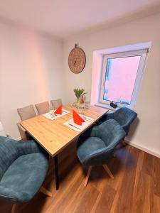 a dining room table with chairs and a clock on the wall at Zwischen Donau & Kurpark in Bad Abbach