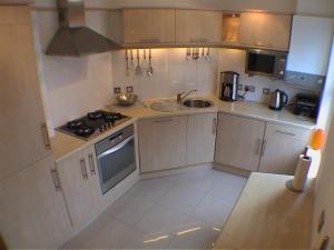a small kitchen with a sink and a stove at Earle House Serviced Apartments in Crewe