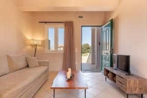 a living room with a couch and a tv at Spiros house in Svoronata