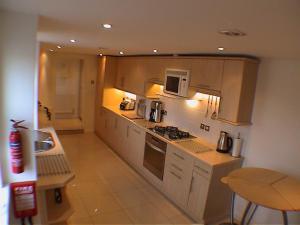 a kitchen with a stove and a microwave at Earle House Serviced Apartments in Crewe