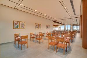 a restaurant with tables and chairs in a room at Keys Select By Lemon Tree Hotels, Chirang in Bongaigaon