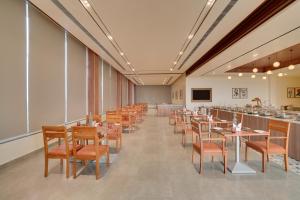 a dining room with tables and chairs and a bar at Keys Select By Lemon Tree Hotels, Chirang in Bongaigaon
