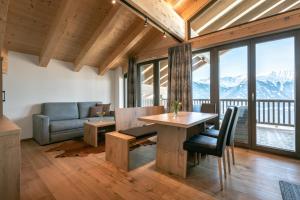 a dining room with a table and a couch at Panorama Apart Weisses Rössl in Reith bei Seefeld