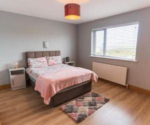 a bedroom with a bed and a window and a rug at Beentee View - Cahersiveen in Cahersiveen