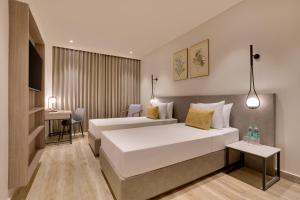 a hotel room with two beds and a table at Keys Select By Lemon Tree Hotels, Chirang in Bongaigaon +62 photos