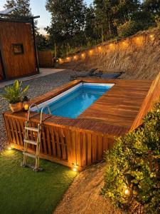 a swimming pool with a ladder next to a wooden deck at Green House in Llagostera