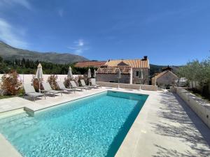 a swimming pool with chairs and a house at Villa Maranta in Slano