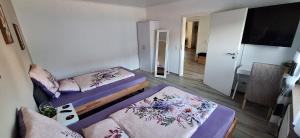 a small room with two beds and a flat screen tv at Ferienhaus an der Ölmühle in Heusweiler