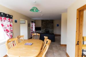 a kitchen and dining room with a wooden table and chairs at 1 Bray Head View in Portmagee +8 photos