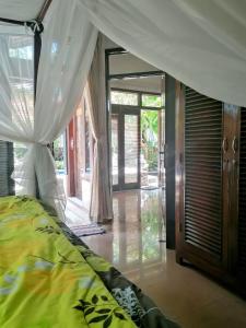 a bedroom with a bed with a canopy at Villa Murni in Lovina +66 photos