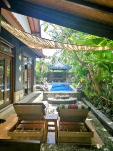 a patio with two chairs and a swimming pool at Villa Murni in Lovina