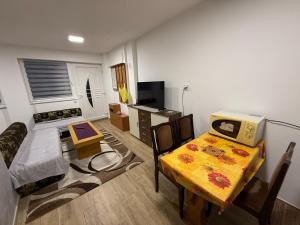 ein Wohnzimmer mit einem Tisch und einem Fernseher in der Unterkunft Apartman Katarina in Foča